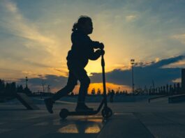 Bästa sommarlekarna tillsammans med barnen: lär er trixa med sparkcykel En pappa och ett barn i åttaårsåldern gör en high five i en lummig svensk skatepark, där barnet står nöjt bredvid sitt rullande åkdon