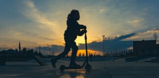 Bästa sommarlekarna tillsammans med barnen: lär er trixa med sparkcykel En pappa och ett barn i åttaårsåldern gör en high five i en lummig svensk skatepark, där barnet står nöjt bredvid sitt rullande åkdon
